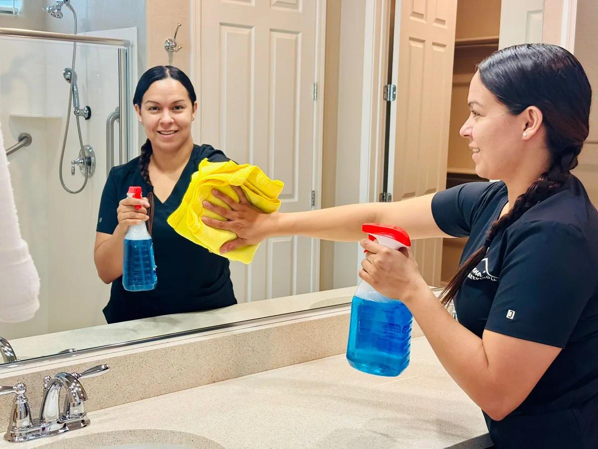 Anna's Housekeeping cleaner wiping down a bathroom mirror in a West Valley Arizona home