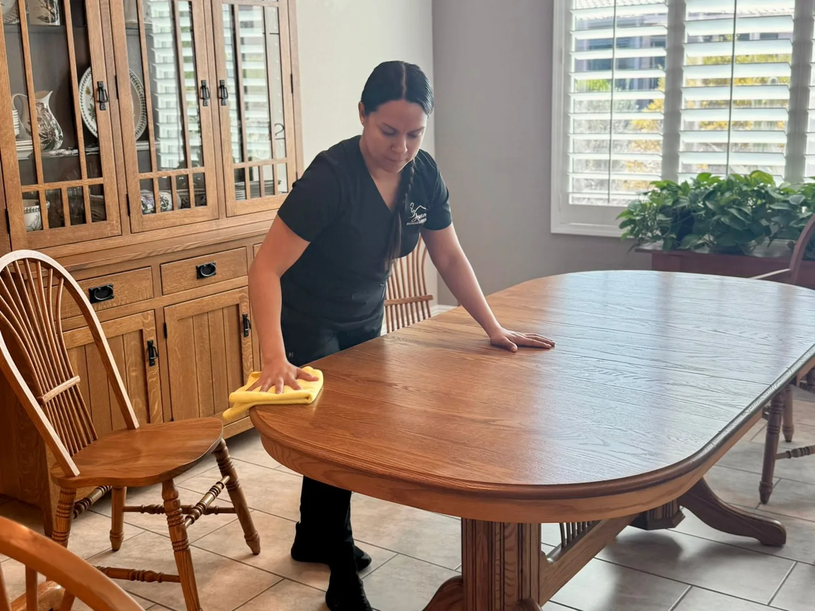 A cleaner from Anna's Housekeeping wiping down a dining table in a Surprise, Arizona home